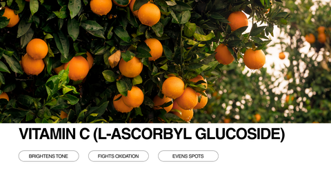 A cluster of ripe oranges hangs on a tree with lush green leaves. Text below reads Vitamin C (L-Ascorbyl Glucoside) and highlights benefits: Brightens tone, Fights oxidation, and Evens spots.