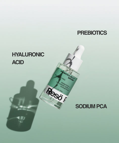 A dropper bottle of RESÖ Bioactive Prebiotics Jelly Serum is displayed on a green gradient background, highlighting Hyaluronic Acid, Prebiotics, and Sodium PCA. This prebiotic gel supports barrier repair and soothing hydration. The bottle casts a shadow.