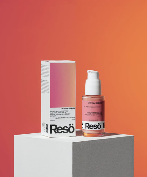 A bottle of Peptide Anti-Aging Serum with a pump stands beside its box on a white pedestal, set against an orange-pink gradient backdrop—highlighting this smoothing, peptide-rich serum for radiant skin.