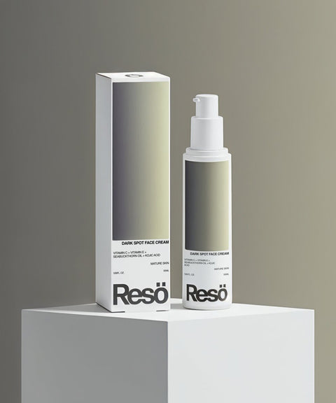 A bottle and box of RESÖ Dark Spot Face Cream with Kojic Acid, featuring a minimalist design and gradient label, are displayed on a white pedestal against a neutral background.