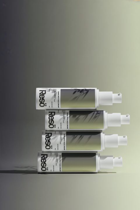 Four Resō skincare serum bottles are stacked horizontally on top of each other against a gradient background, with abstract shadows cast across the bottles and a soft, modern aesthetic.