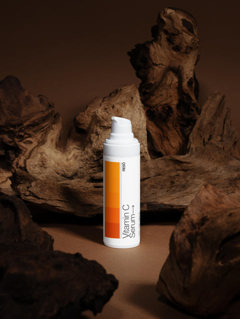 Vitamin C serum bottle with an orange label on a brown background