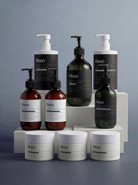 THE COMPLETE COLLECTION by Resö, featuring pump bottles and round jars with minimalist labels, is neatly arranged on white blocks against a gray backdrop for a modern, cohesive display.