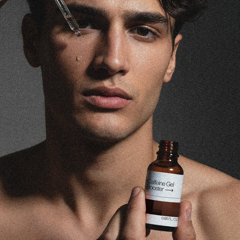 Man holding a bottle labeled 'Caffeine Gel Booster' against a dark background