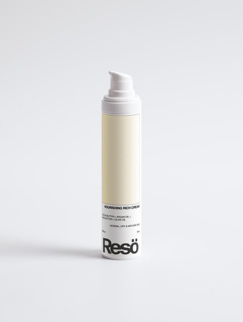 A white bottle with a pump dispenser labeled Resö Nourishing Rich Cream stands upright on a plain white background. The label mentions ingredients like shea butter and jojoba oil for normal, dry, and mature skin.