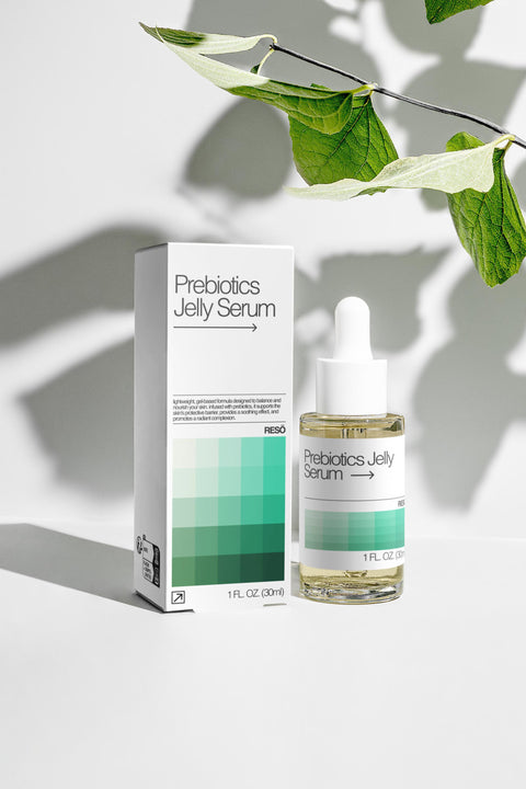 Prebiotics Jelly Serum bottle and packaging on a light background with leaves.