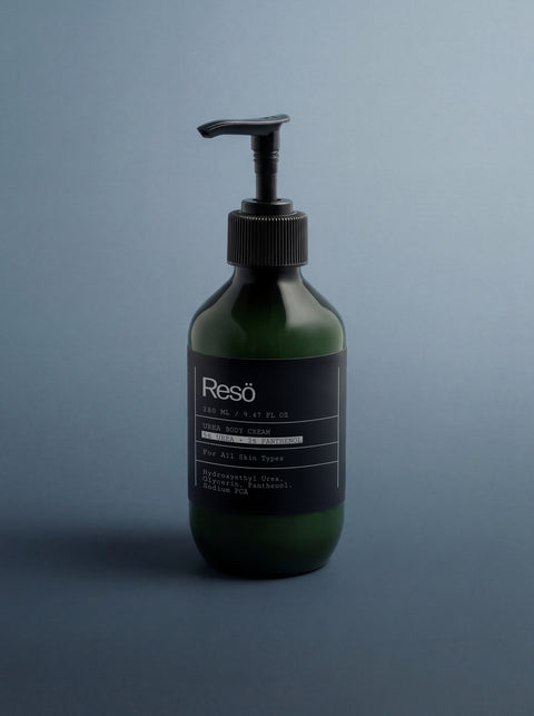 A green bottle of 5% Urea + 2% Panthenol Body Cream with a black pump stands on a blue background. The label highlights its hydrating formula, suitable for all skin types and ideal for smoothing keratosis pilaris.